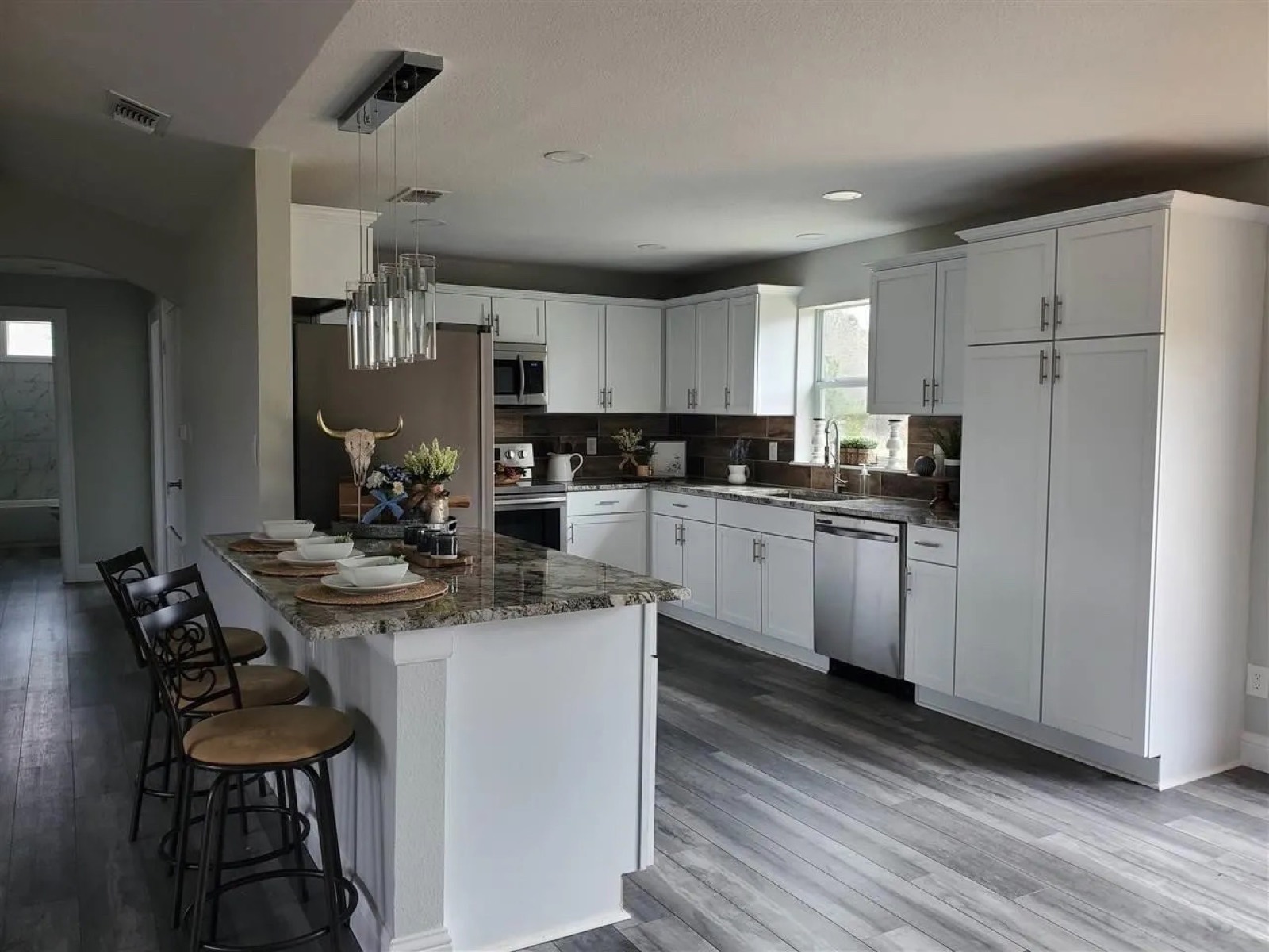 Remodeled kitchen with white shaker cabinets and an island